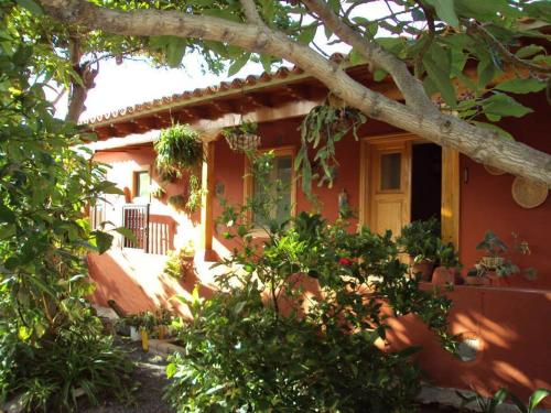 サン・セバスティアン・デ・ラ・ゴメラにあるCasa Rural Finca La Lagunaの目の前に植物の集まる赤い家