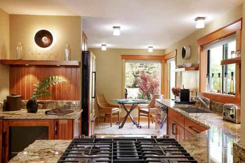 a kitchen with a stove and a table in it at Tu Tu'Tun Lodge in Gold Beach