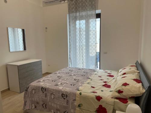 a bedroom with a bed with a flowered blanket at RussoHome in Monte di Procida