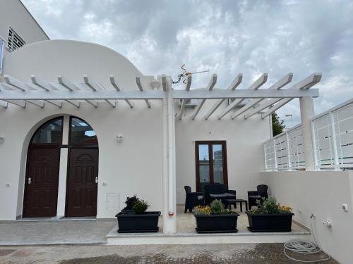 a white house with a pergola and some plants at RussoHome in Monte di Procida