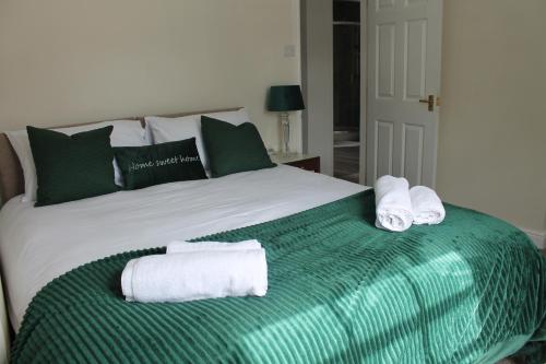 a green and white bed with towels on it at Shrewsbury Georgian town house - Hills Lane in Shrewsbury