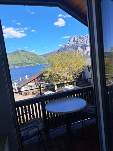 a balcony with a table and a view of the water at Ferienwohnung direkt am See 3 in Altmünster