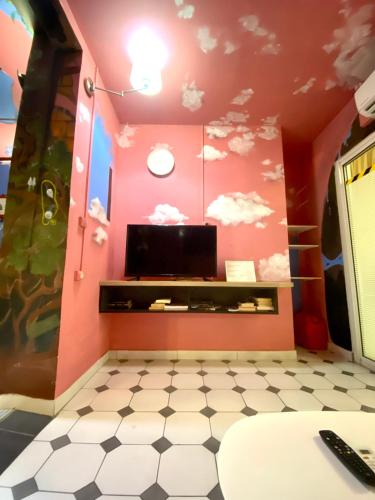 a room with a tv and clouds painted on the wall at Le Patio Foyalais in Fort-de-France