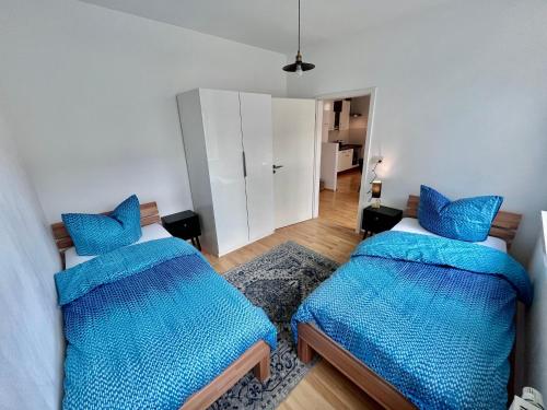 two beds in a room with blue pillows at Apartment in Grimma mit 2 Schlafzimmer in Grimma