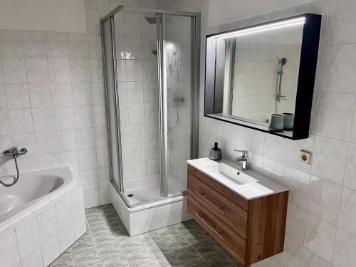 a bathroom with a shower and a sink and a tub at Apartment in Grimma mit 2 Schlafzimmer in Grimma