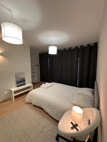 a bedroom with a bed and a table and a chair at Pereira Azurara 3 quarto 3D in Póvoa de Varzim