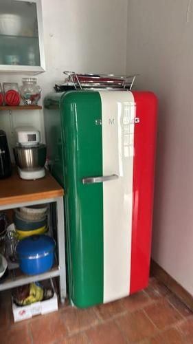 - un réfrigérateur rouge blanc et vert dans la cuisine dans l'établissement Villa Maison Roberto, à Lerné