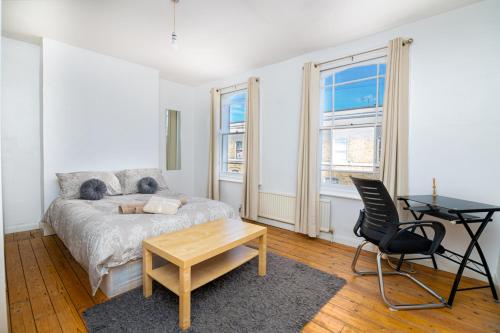 a bedroom with a bed and a table and a desk at Bright Spacious Double Bedroom in London