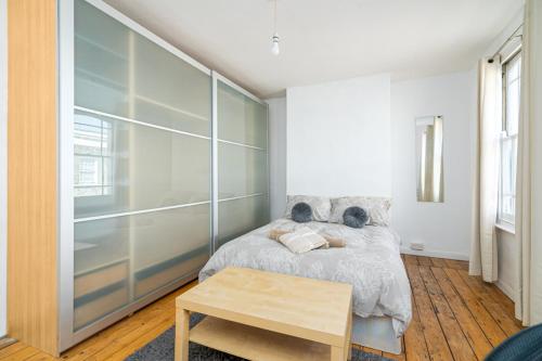 a bedroom with a bed and a table at Bright Spacious Double Bedroom in London