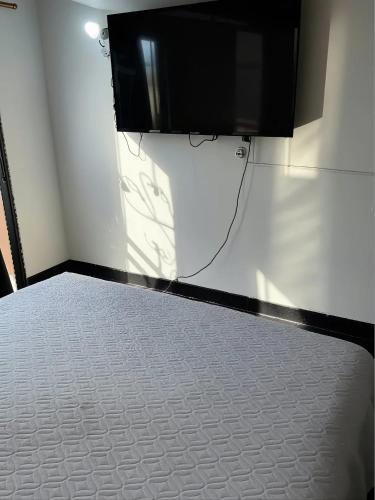 a room with a flat screen tv on a wall at Aparta suites torre de prado 504 in Medellín
