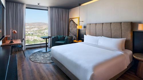 a hotel room with a large bed and a window at Vetta, Distrito Uno, Autograph Collection in Chihuahua