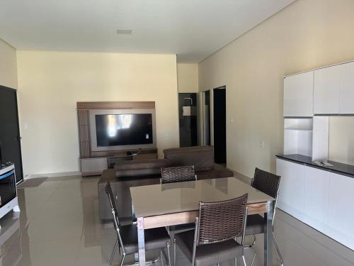 a living room with a table and a television at Rancho Caminho Iluminado in Piumhi