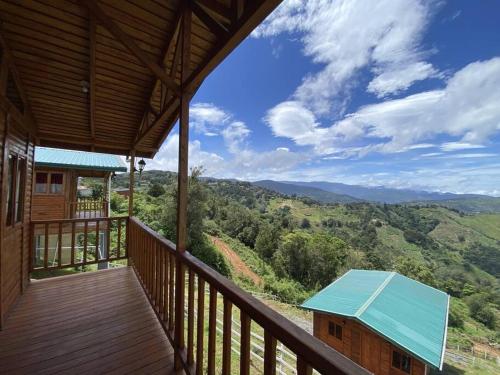 a balcony of a house with a view of the mountains at Cabaña Girasoles - CUTE Cabin with Amaizing views! in Jardín