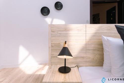 a lamp sitting on a table next to a bed at Full Moon Guesthouse in Dubai