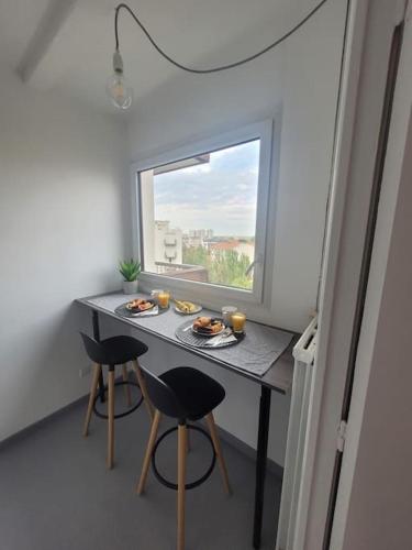 - une petite table avec de la nourriture dans une chambre avec une fenêtre dans l'établissement Studio Cosy proche Métro, à Aubervilliers