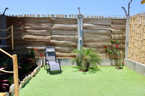 a patio with two chairs and a grass yard at La Vidita 890 - Piscinas, Lobitos in Lobitos