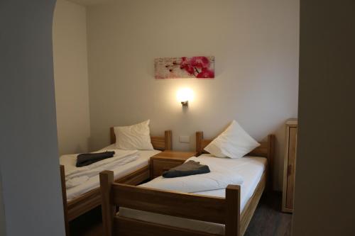 Habitación pequeña con 2 camas individuales y lámpara en Hotel SINOS, en Klagenfurt