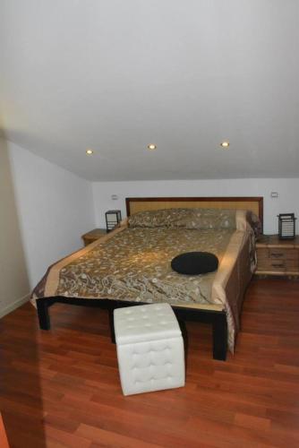 a bedroom with a bed with a table and a stool at Villa Gioia in Acqui Terme