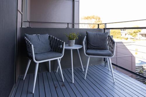 two chairs and a table on a balcony at Torquay Golf Retreats - Pool, Beach, Tennis, Golf in Torquay