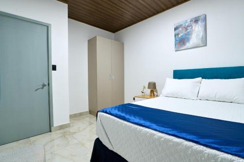 una camera con un letto blu e bianco e una porta di APARTAMENTO LA CAPITAL a San José
