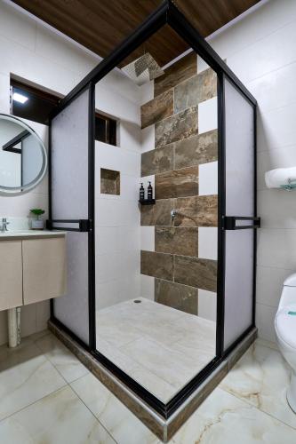 un bagno con doccia con porta in vetro di APARTAMENTO LA CAPITAL a San José