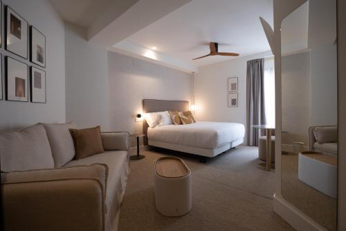 een hotelkamer met een bed en een bank bij Hotel Cetina Casa de Aguilar in Córdoba