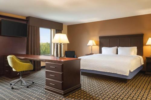 a hotel room with a bed and a desk and a desk at Hampton Inn & Suites Pine Bluff in Pine Bluff