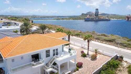 a house with a view of the water and a ship at Artiko Luxury Suites - Jan Thiel in Jan Thiel