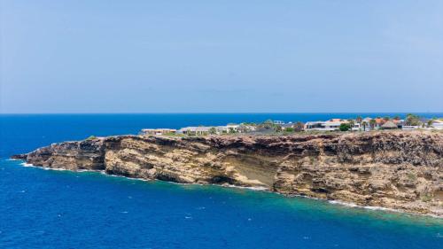an island in the ocean with houses on it at Artiko Luxury Suites - Jan Thiel in Jan Thiel