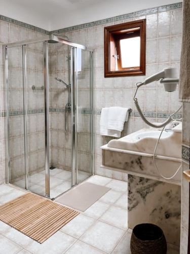 a bathroom with a shower and a sink and a tub at Casa Buna Colorada in Playa Blanca
