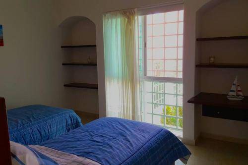 een slaapkamer met een bed en een groot raam bij House completely furnished Total privacy 8Pax in Cancun