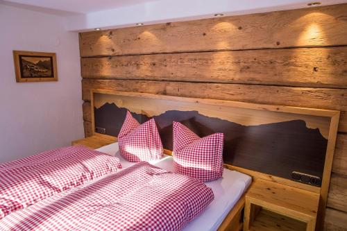 a bedroom with a bed with red and white checkered pillows at Gästehaus Fritz in Mittelberg