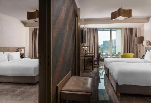 a hotel room with two beds and a desk at Radisson Blu Hotel Istanbul Ottomare in Istanbul