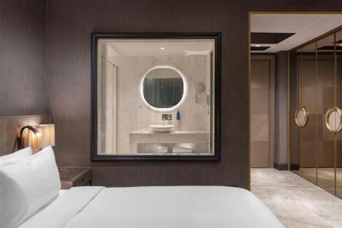 a bathroom with a bed and a mirror and a sink at Radisson Blu Hotel Istanbul Ottomare in Istanbul