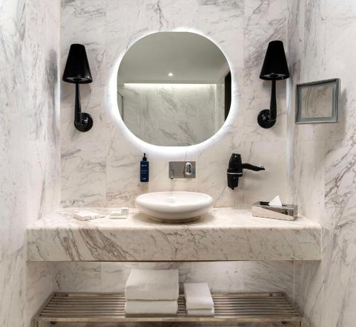 a white bathroom with a sink and a mirror at Radisson Blu Hotel Istanbul Ottomare in Istanbul