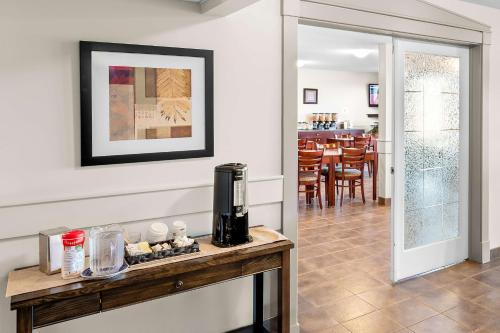 a kitchen and dining room with a table with a coffee maker at SureStay Plus Hotel by Best Western Hardisty in Hardisty