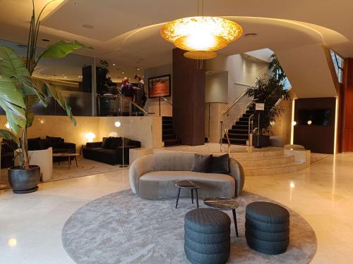 a living room with a couch and tables and stairs at Best Western Premier CMC Girona in Girona