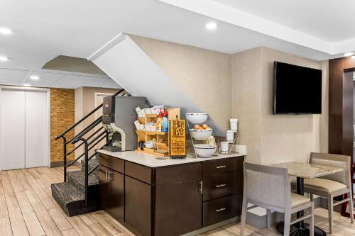 a living room with a kitchen and a staircase at Best Western West Lebanon-Hanover in West Lebanon