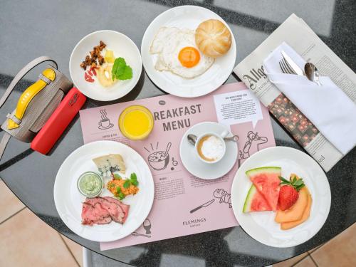 four plates of breakfast meals on a table at Flemings Selection Hotel Frankfurt-City in Frankfurt/Main