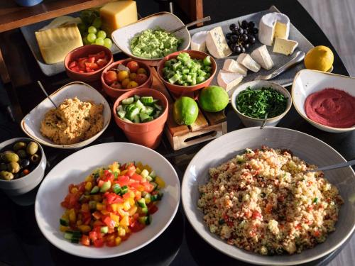 a table topped with bowls of different types of food at Flemings Selection Hotel Frankfurt-City in Frankfurt/Main