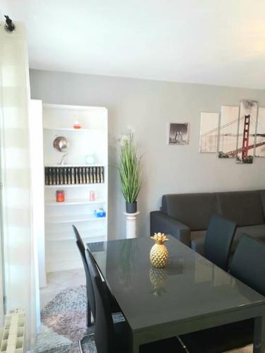 un salon avec une table et un canapé dans l'établissement Location appartement 3 pièces à 200 m de la gare 5 pers max, à Cormeilles-en-Parisis