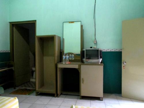 Habitación con tocador, TV y espejo. en Hotel Anugerah Bondowoso, en Bondowoso