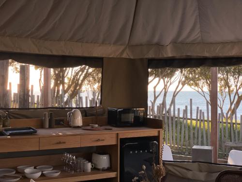a kitchen with a view of the ocean through windows at Te Whaanga Retreat & Spa in Raglan