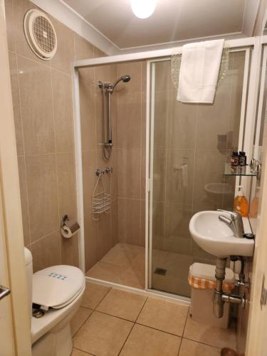 a bathroom with a shower and a toilet and a sink at Getaway Inn Boutique Guest house in Nulkaba
