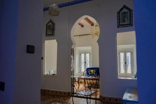 sala de estar con arco y comedor en Authentic Dual Terrace house, en Chefchaouen