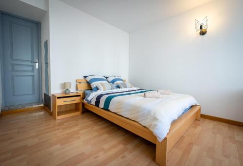 une chambre avec un lit avec des draps bleus et blancs dans l'établissement La Rochelle - Deux appartements pour 10 personnes, à Aytré