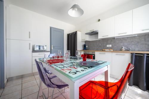 une cuisine avec une table et des chaises dans une cuisine dans l'établissement La Rochelle - Deux appartements pour 10 personnes, à Aytré