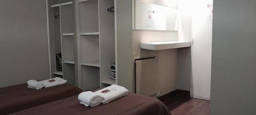 a room with two beds with white towels on them at Hotel Kapac in Mendoza
