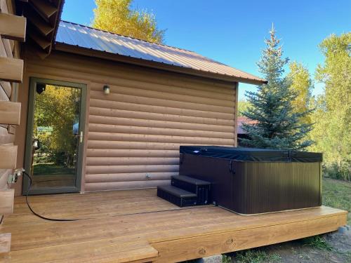 a screened in porch with a tv on a deck at Brown Bear Cabin in South Fork