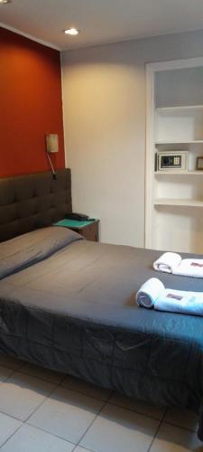 a bedroom with a bed with two towels on it at Hotel Kapac in Mendoza